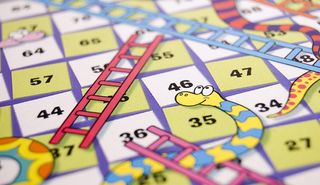 Photo of the board game snakes and ladders. Snakes and ladders is how many people say the brain injury recovery process feel like.